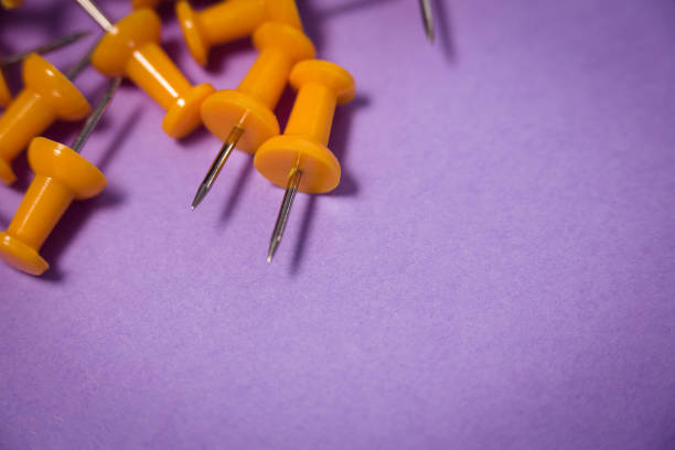 istock High angle view of yellow paper pins on paper 879949720