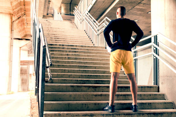 młody sportowiec przygotowuje się do wyzwania w środowisku miejskim. - determination running staircase jogging zdjęcia i obrazy z banku zdjęć