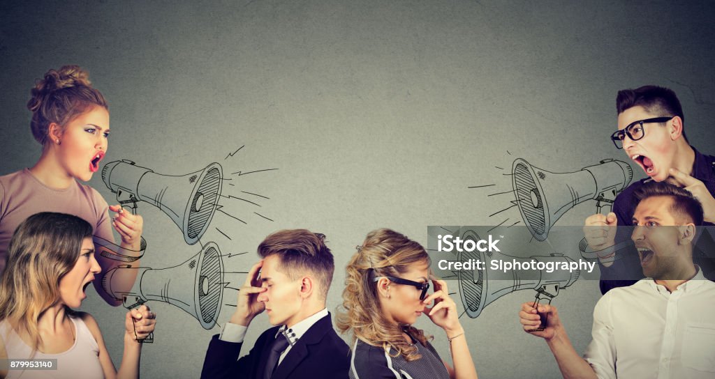 Group of people men and women screaming in megaphones at sad depressed young couple People Stock Photo