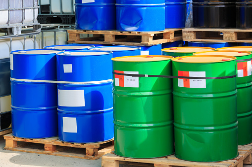 Big green and blue barrels standing on wooden pallets on a chemical plant
