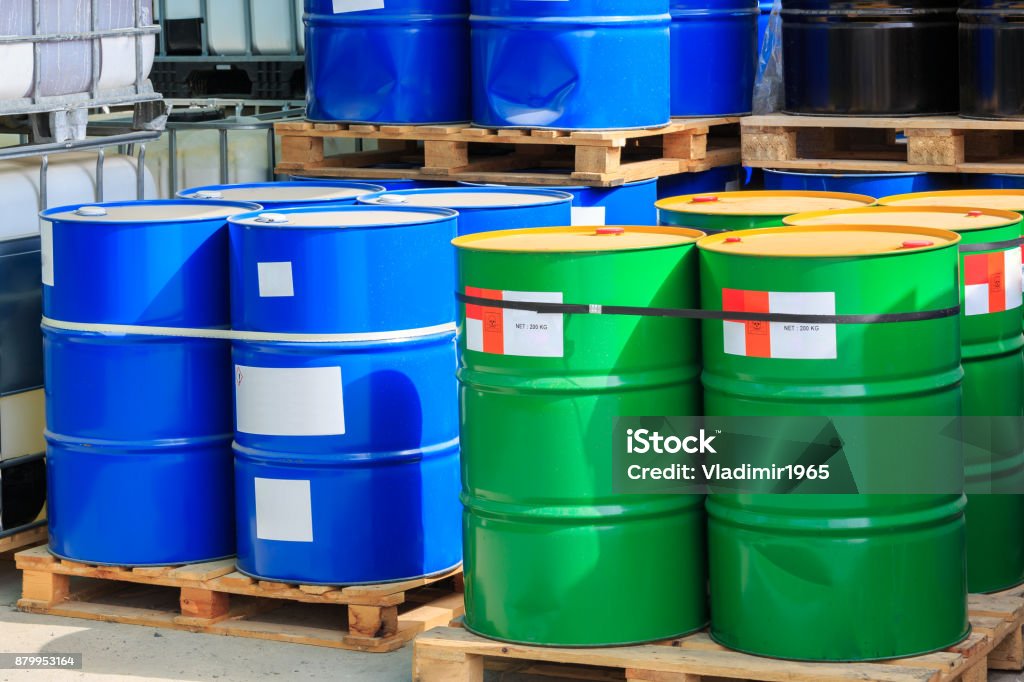 Big green and blue barrels on wooden pallets Big green and blue barrels standing on wooden pallets on a chemical plant Garbage Stock Photo