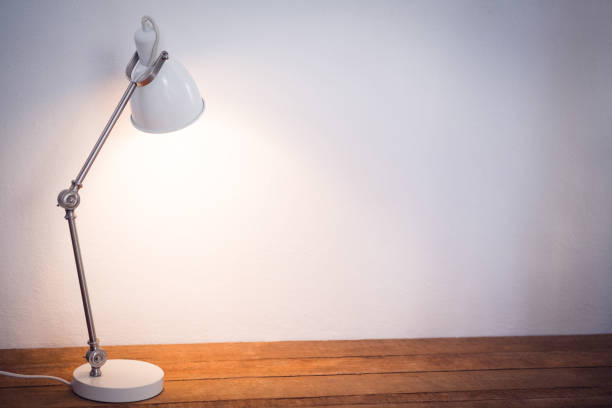istock Illuminated electric lamp on wooden table 879957090