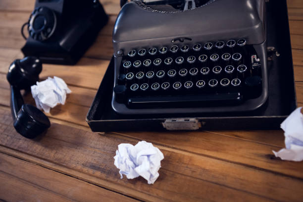 istock High angle view of typewriter by telephone and crumpled papers 879957126
