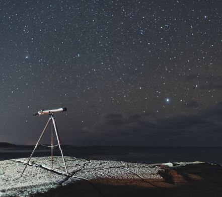 A small telescope points to the Orion constellation near the Atlantic coast.  Long exposure.