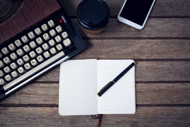 istock Overhead view of typewriter by disposable cup and book 879964442