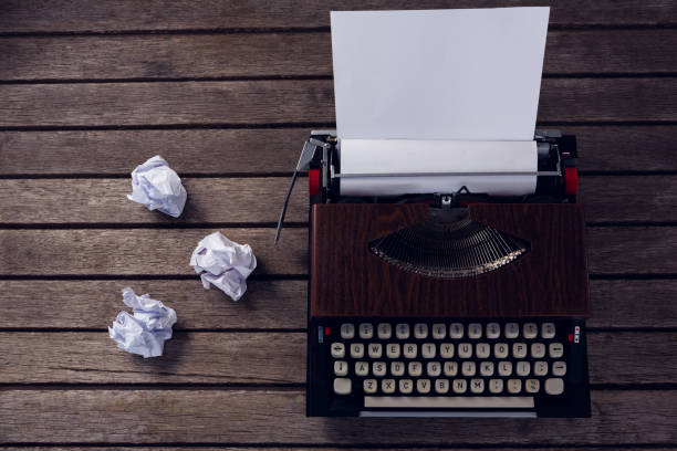 istock Vintage typewriter and crumbled paper on wooden table 879970062