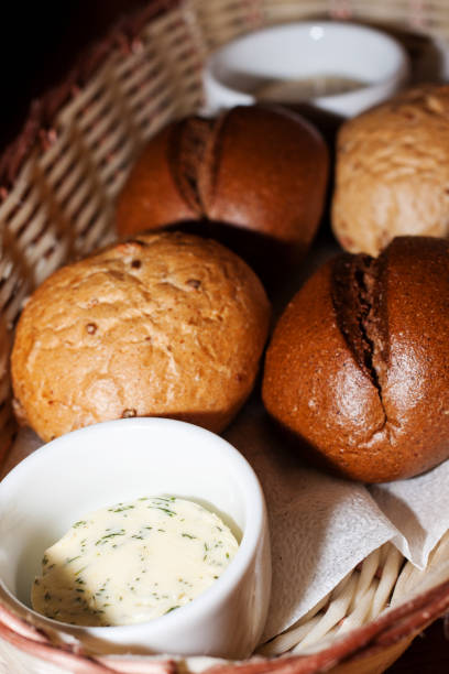 istock Assorted bread rolls in a wicker basket with sauce and butter in a close-up restaurant 879970284