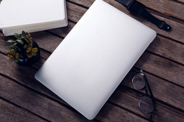 istock Laptop, diary, pot plant, spectacles and smart watch on wooden table 879976664