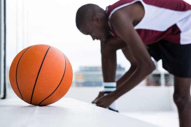 istock Basketball player tying shoelace 879989594