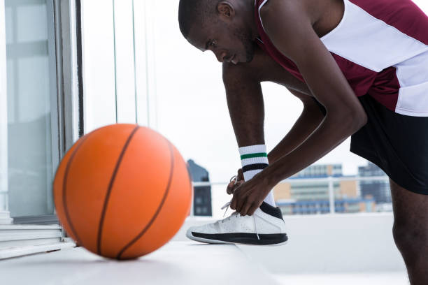 istock Basketball player tying shoelace 879989598