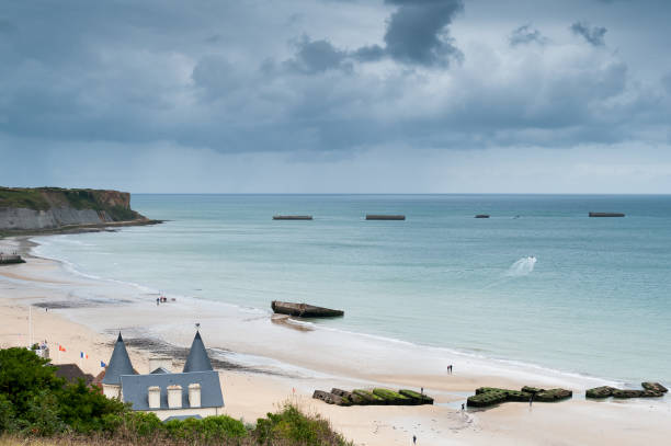 istock Beach at Arromanches with vestiges of the WW2 artificial harbor 879994532