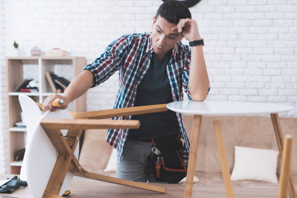 istock The young man tries himself to fold his coffee table and stools. 880005688