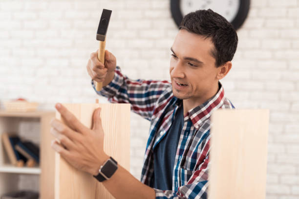 istock The young man tries himself to fold his bookcase. 880005878