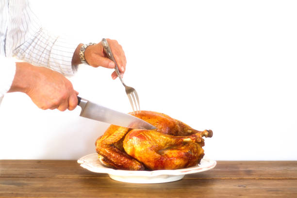istock Man's Hands Carving Turkey on Platter, White Background 880038252