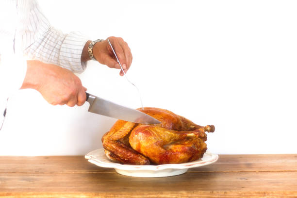 istock Man's Hands Carving Turkey on Platter, White Background 880038308