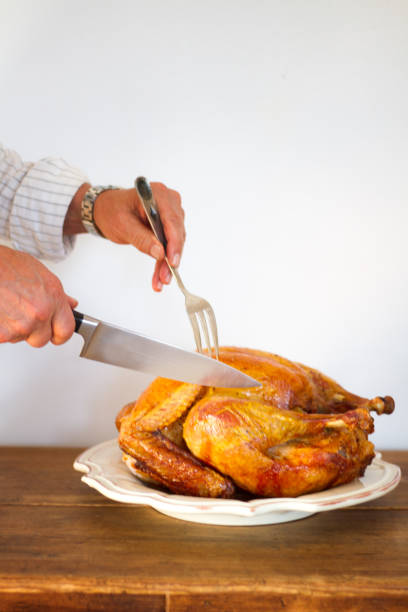 istock Man's Hands Carving Turkey on Platter, White Background 880045022