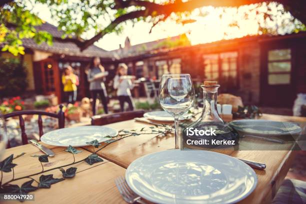 Preparación De Mesa De Comedor En El Patio Del Patio Trasero De La Familia Foto de stock y más banco de imágenes de Familia