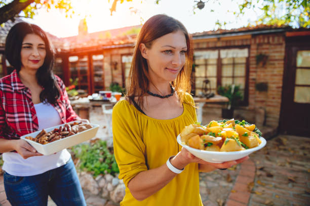 istock Woman carrying a bowl with roasted potatoes 880047974
