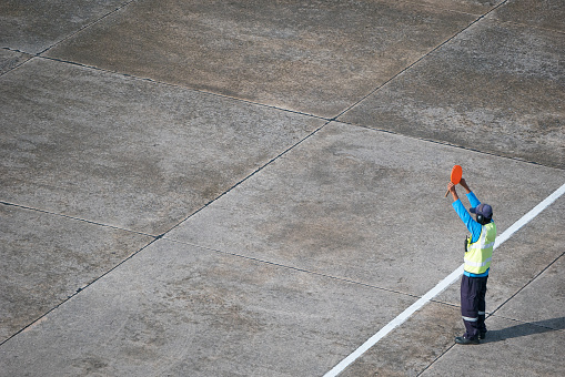 Marshaller signalling to stop the aircraft at the airport apron