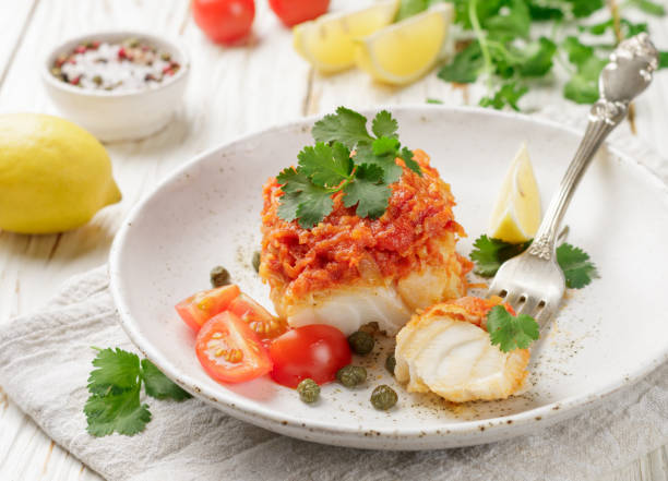 istock White fish (cod, Pollock, nototenia, hake), braised with onions, carrots and tomatoes. Vegetable marinade. Delicious hot or cold snacks for foodies. Selective focus 880056536