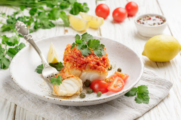 istock White fish (cod, Pollock, nototenia, hake), braised with onions, carrots and tomatoes. Vegetable marinade. Delicious hot or cold snacks for foodies. Selective focus 880056548