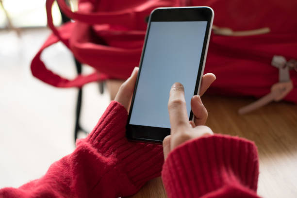 istock woman wearing red sweater using smartphone for social networking. girl typing text message on application in mobile phone. technology, communication 880057160