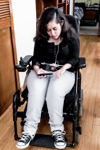 disabled girl with smartphone at home - motorized wheelchair audio imagens e fotografias de stock