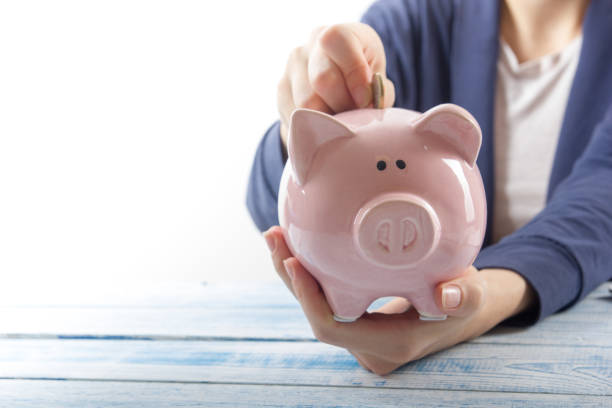 istock Hand putting coin into piggy bank closeup. selective focus 880108952