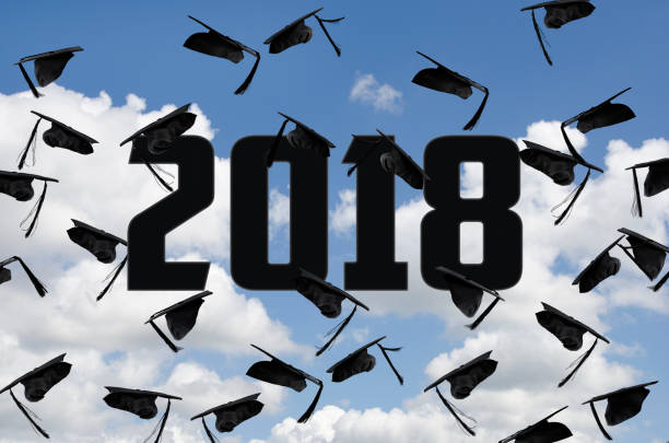 istock black 2018 graduation hats in sky 880116648