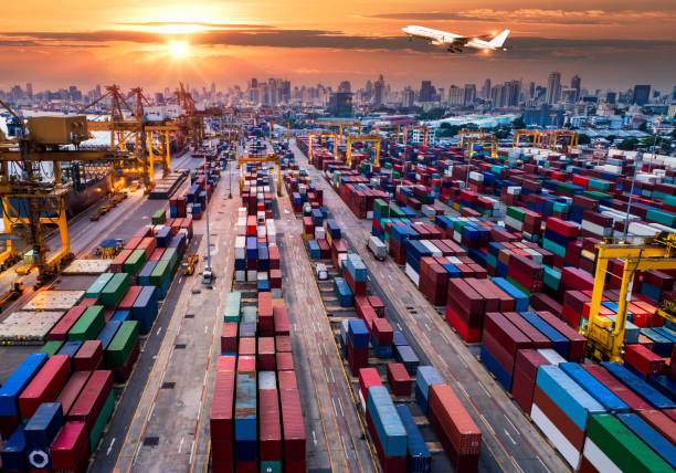 containerschiff im import-export und logistik. handelshafen. versand, fracht, hafen und frachtflugzeug mit kranbrücke in werft bei sonnenaufgang, logistische arbeiten import/export und transport hintergrund in der industrie - harbor city stock-fotos und bilder