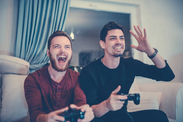 istock Two Excited Friends Playing Video Games 880133562