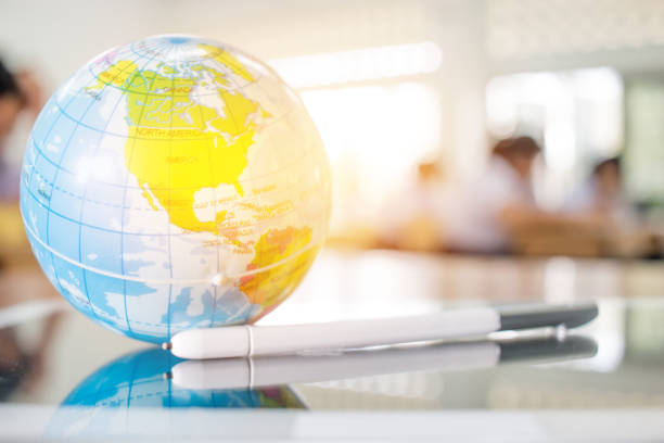 istock Earth globe model, America maps in Global ball put on Tablet with stylus pen for learning in teacher desks in high school, students blur background, white, black tone. Geography subject of learning. 880133688
