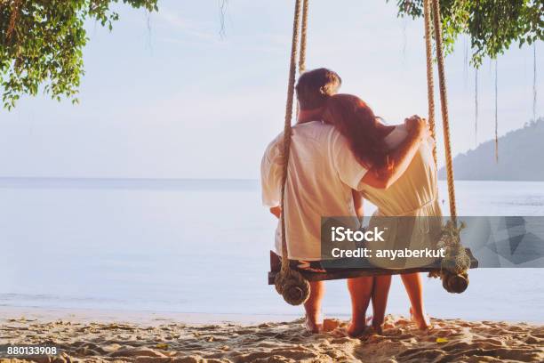 ロマンチックな休暇新婚旅行スイングにビーチで愛情のこもったカップル - カップルのストックフォトや画像を多数ご用意 - カップル, 浜辺, ロマンス