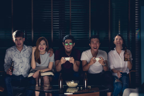 gruppo di amici che giocano ai videogiochi in tv a casa. - friendship video game young adult party foto e immagini stock