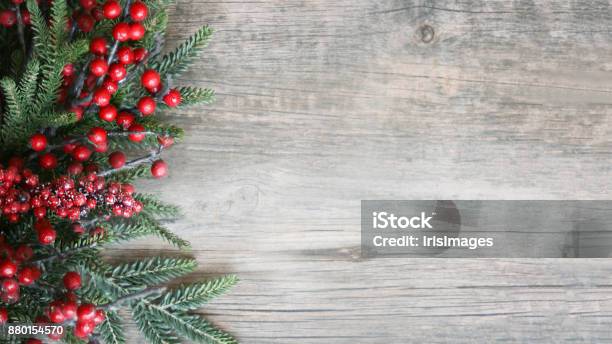 Holiday Evergreen Branches And Berries Over Wood Stock Photo - Download Image Now - Christmas, Backgrounds, Holiday - Event