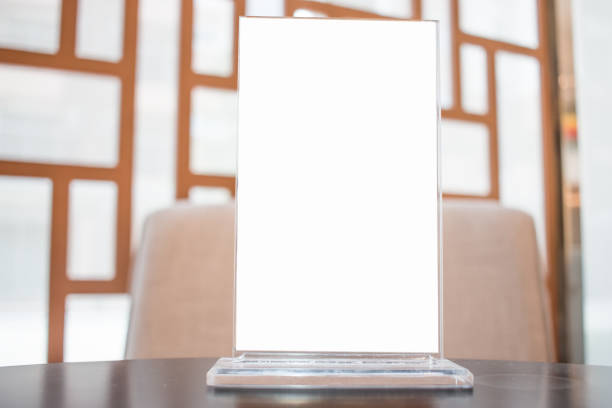 istock Mock up white Label for blank menu frame in Restaurant, Stand for booklets with white sheets paper tent card on table cafeteria, blurred background can insert for text of customer. 880157440