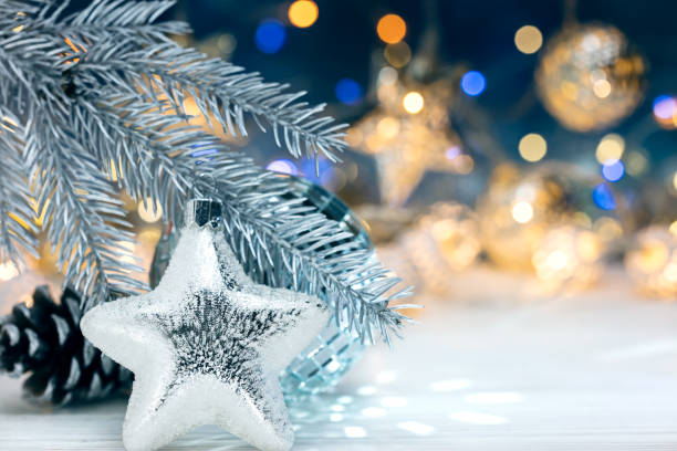 istock fir tree branch with silver star against blurred christmas lights background 880167152