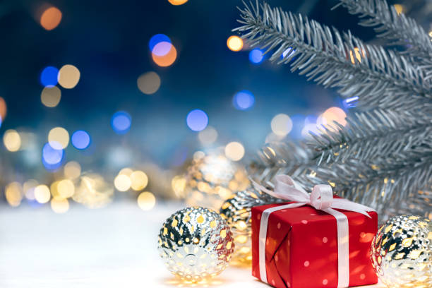 istock red gift box with christmas fir tree decorations branch on blurred lights background 880167428