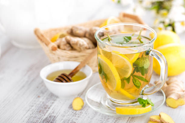 aromatisierter kräutertee mit frischer zitrone, ingwer und minze blätter auf weißem hintergrund, nahaufnahme - mint tea lemon tea leaves glass stock-fotos und bilder