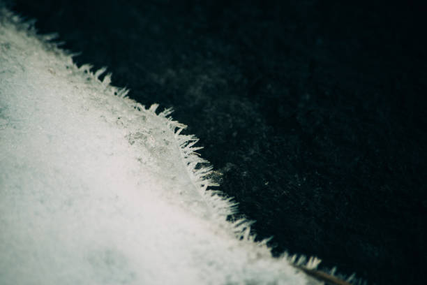 istock Ice fragments under thin layer of frozen river water. Dark blue natural background 880182362