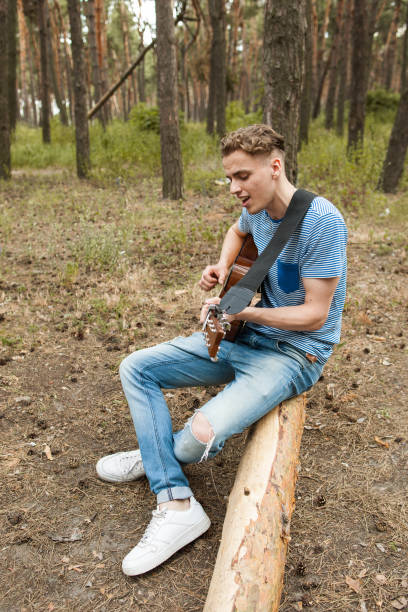 istock Handsome man song playing guitar forest concept. 880189958