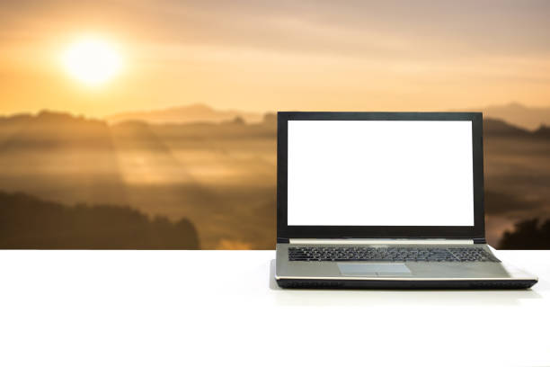 istock Laptop on white desk with blurred scene sunlight shine on mountain at sunrise 880208152