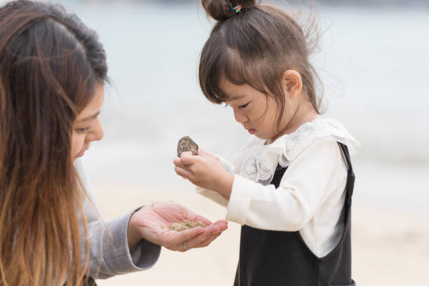 istock Mother and daughter playing in the beach 880213690