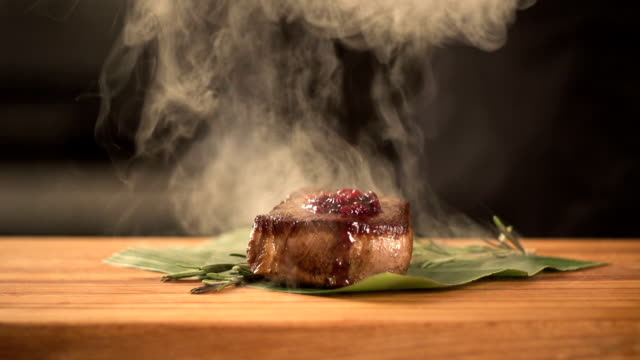 chef cooks food in the kitchen. Fry steak meat. final serving dish. slow motion