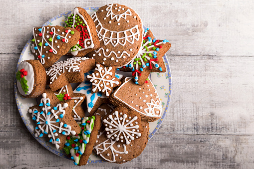 Top down view of traditional Christmas cocoa crinkle cookies in a colorful plate, surrounded by Christmas ornaments.