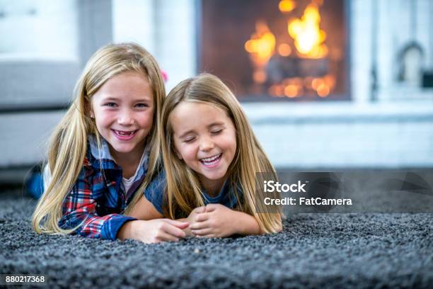 Two Sisters Lying On The Floor Stock Photo - Download Image Now - Carpet - Decor, Family, Fireplace