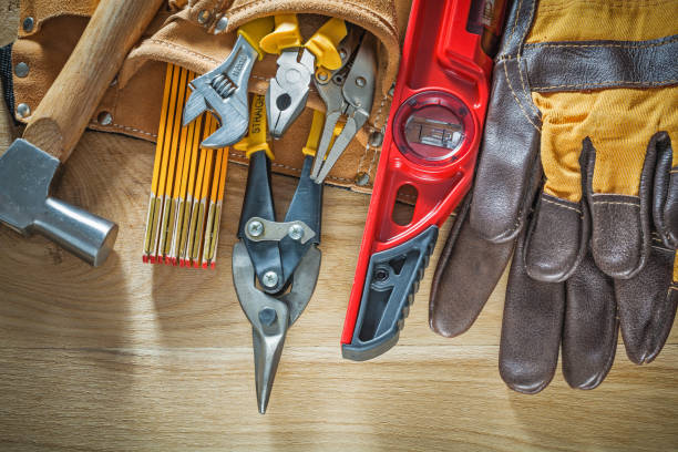 istock Tool belt with tooling construction level safety gloves on woode 880252344