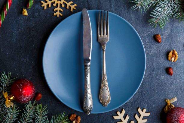 istock On a blue plate, an old knife and fork, around Christmas decorations. 880299878