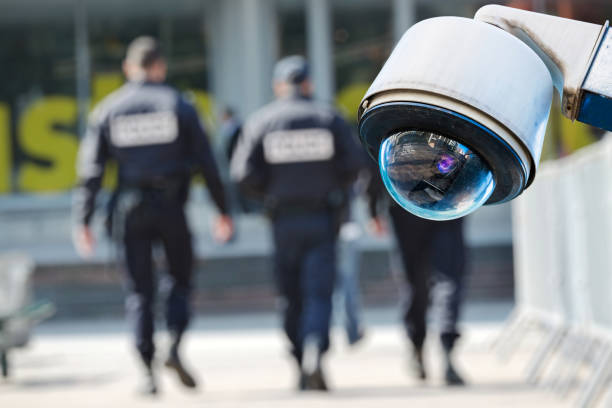 камеры видеонаблюдения или системы наблюдения с военными на размытом фоне - public safety стоковые фото и изображения