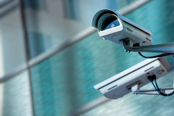 istock cctv security camera in a city with blury business building on background 880300444